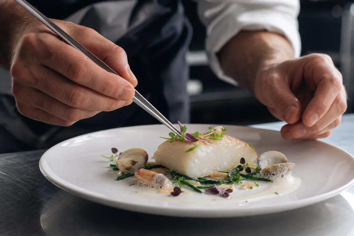 Chef dressant une assiette gastronomique à base de produits de la mer